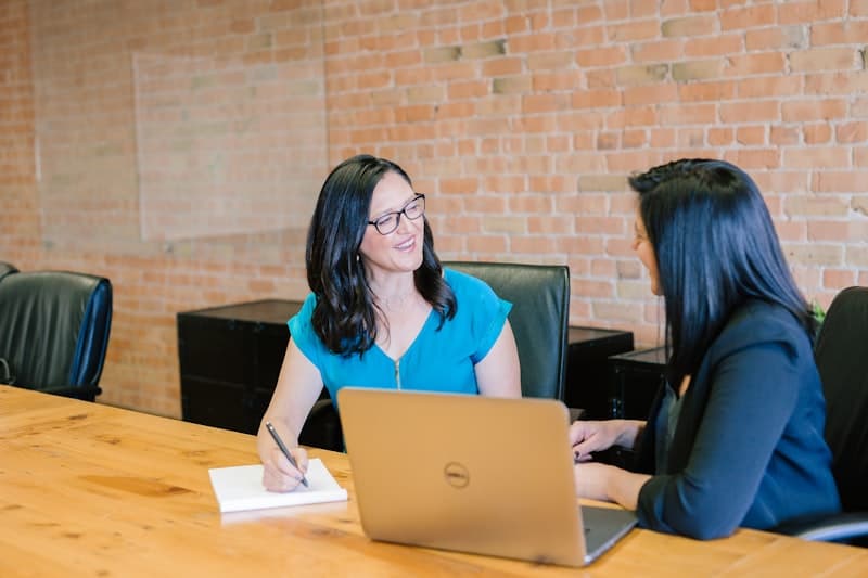 Two HR professionals discussing employee matters at a desk